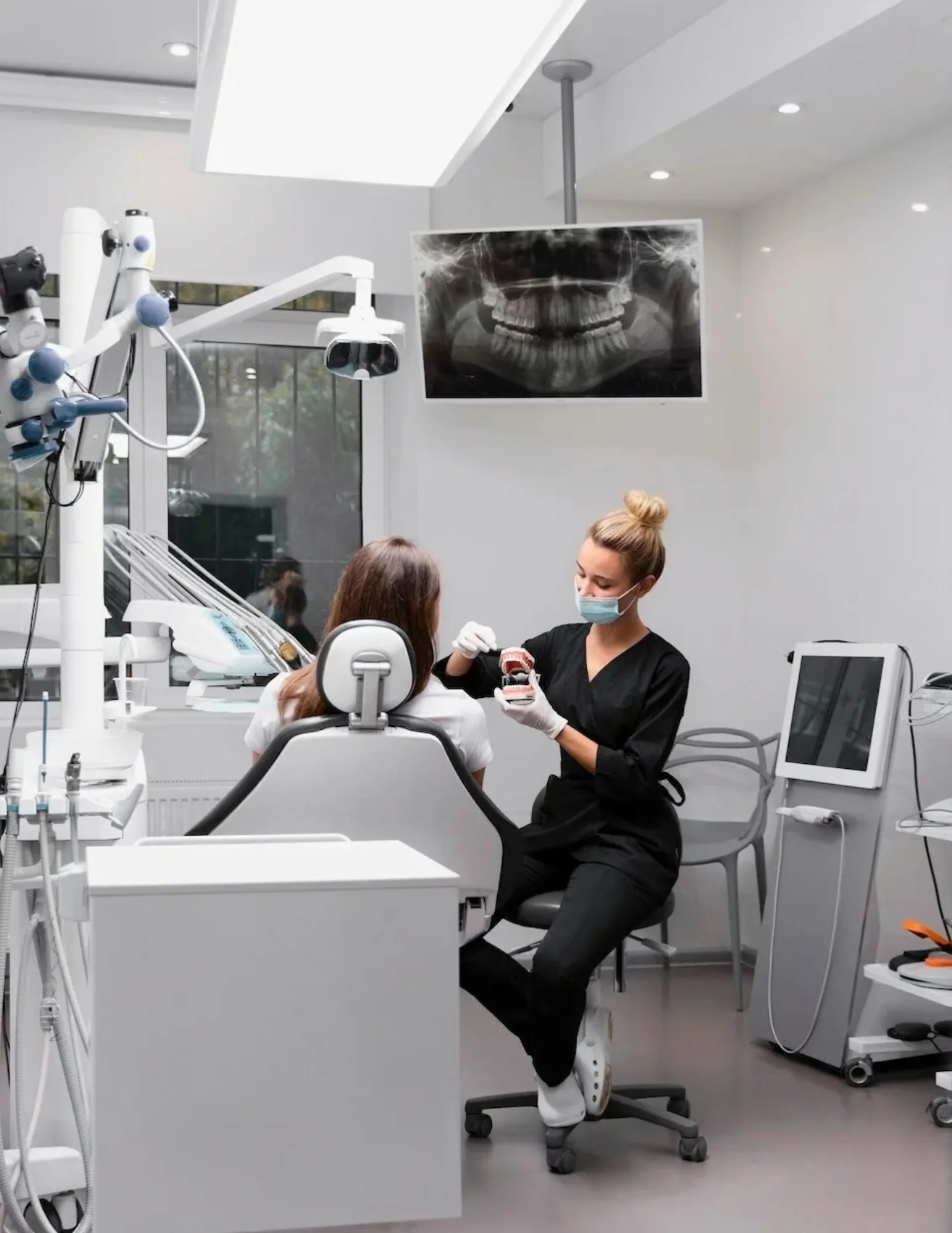 Dentist in chair conducting an x-ray scan of the mouth
